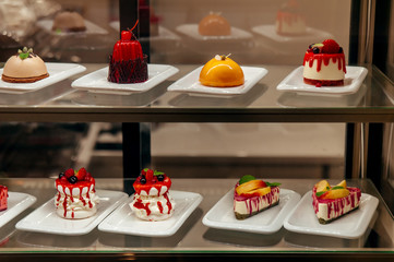 many little cakes beyond showcase in shop is on sale