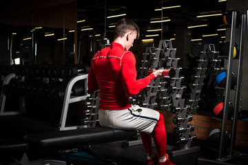 the sportsman is engaged in an exercise room, pumps muscles, a biceps and a press