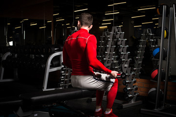 the sportsman is engaged in an exercise room, pumps muscles, a biceps and a press