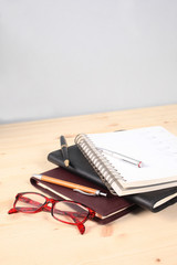 agendas and pens piled on a wooden table with copy space