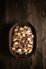 Lamb Loin Chops with Vegetables in Rustic Clay Dish Prepared for Roasting. Copy Space.
