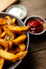 Baked potato fries on wooden table