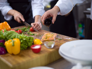 Chef hands preparing marinated Salmon fish
