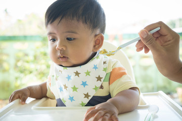 Cute asian baby bored with food