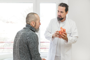 Kardiologe spricht mit Patient über das Herz und die Herzkrankheiten