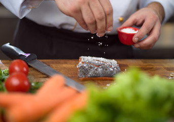 Chef hands preparing marinated Salmon fish