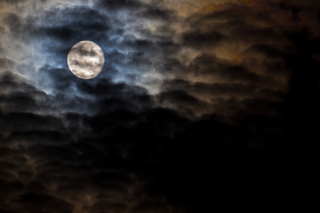 Naklejka na ściany i meble The moon behind the dark clouds