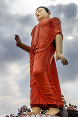 Fototapeta na wymiar large statue of Buddha rises above the city against a sky with clouds