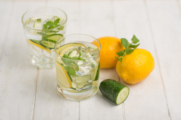Infused water detoxification with cucumber, lemon and mint in the glass on a white table. Diet, healthy diet, the concept of weight loss.