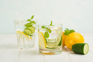 Infused water detoxification with cucumber, lemon and mint in the glass on a white table. Diet, healthy diet, the concept of weight loss.