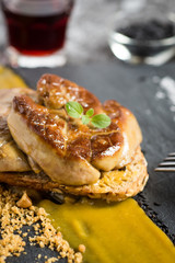 Fried Foie Gras with Mango Puree on Dark Stone Background. Duck Liver.