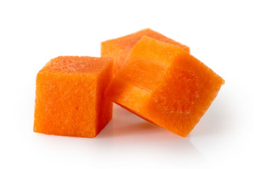 Detail of three squares of diced carrot isolated on white.