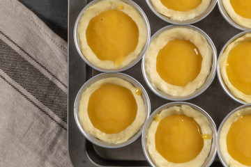 Traditional portuguese dessert pastel de nata before going to the oven. Dough of custard egg tarts