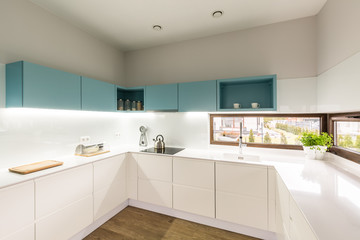 Fototapeta na wymiar Iilluminated modern white turquoise kitchen