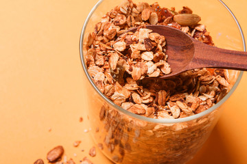 Granola in a glass jar on a yellow background