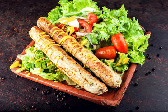 Grilled sausage with vegetables and mostard on wooden board