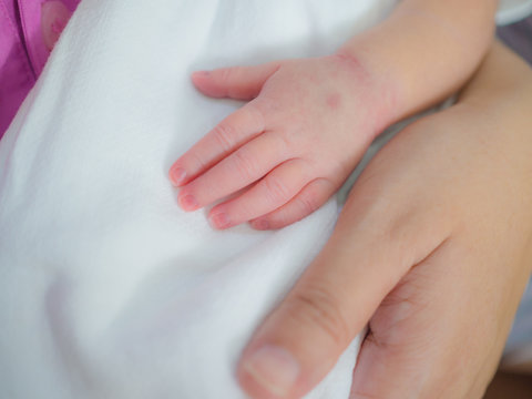 mother day and new born concept from mother's hand hold with small baby foot and hand with soft focus background