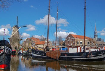 Windmill De Roode Leeuw and antique ships in canal. Turfsingel Gouda, the Netherlands.