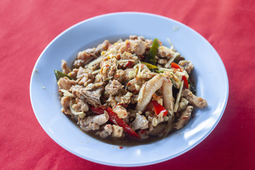 Thai food, Red curry chicken in dish blue color put on red fabric.