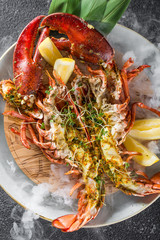 Grilled lobster with lemon baked in Josper oven. Served on the plate with dry ice