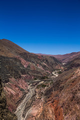 Fototapeta premium View of Iruya village and multicolored mountains in the surroundings at sunset, Salta province, Argentina, iruya - San Isidro - San Juan treeking