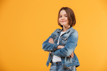 Portrait of a smiling little schoolgirl standing with hands