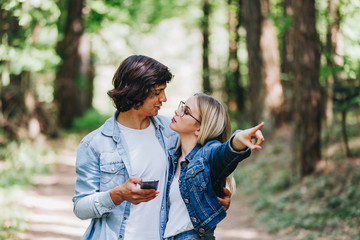 Young couple on adventure in forest using GPS on smartphone as orientation
