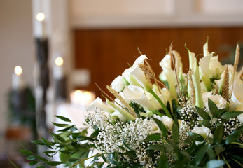 Naklejka premium kwiaty na ołtarzu w kościele i świece na tle