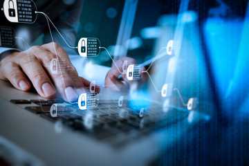 designer hand working and smart phone and laptop on wooden desk in office