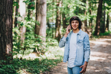 Young man talking on phone while standing in forest