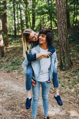Fototapeta premium Young romantic couple hugging, kissing and having fun while they have vacation in forest