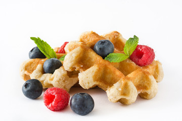 Traditional belgian waffles with blueberries and raspberries, isolated on white background. 
