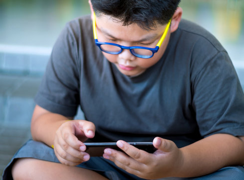 Asian Boy Have A Serious Face While Playing Game On Smartphone