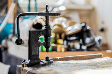 Vintage hand-press for setting rivets on clothes. The shoemaker's workshop.