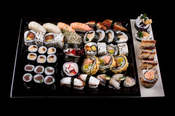 Large sushi set on the black background.