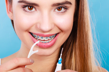 Woman with braces cleaning teeth with toothbrush