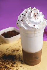 plastic cup of delicious iced cappuccino coffee and cold milk mix with whip cream topping