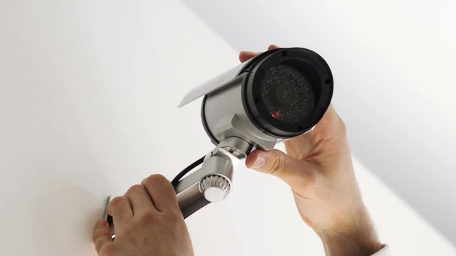 Installing a security camera indoors on a wall. CCTV surveillance installation.