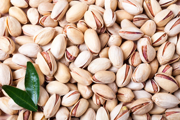 Pistachios background. Pistachio texture with leaves. Nuts. Top view