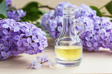 Obraz na płótnie Canvas Lilac flowers oil bottle