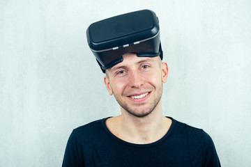 portrait of a young handsome bald man wearing a virtual reality mask (glasses) on a white background. the concept of video games and reality
