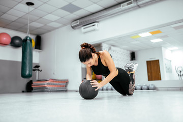 Beautiful strong woman doing push up on ball at the gym.