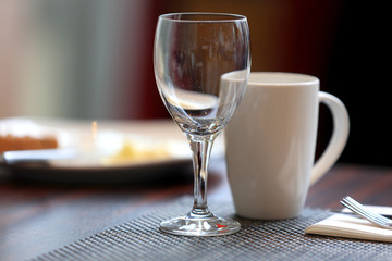 Wine glass and coffee cup on breakfast table