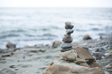 Image of Pebble tower on the beach. Stone wishing Pyramid on the shore of the sea