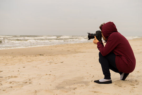 Woman taking pictures on coastline