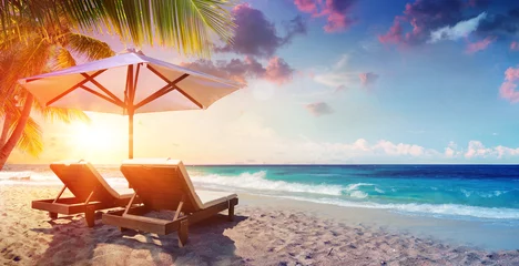 Poster Twee ligstoelen onder parasol in tropisch strand bij zonsondergang © Romolo Tavani