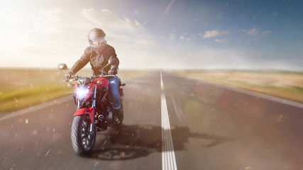 Fototapeta na wymiar Motorrad fährt auf freier Landstrasse