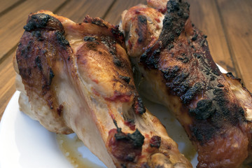 Appetizing roast turkey shank on a plate close up