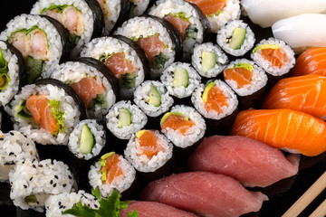 Large sushi set on the black background.