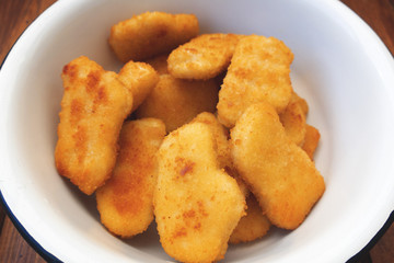 Appetizing, bright and beautiful chicken nuggets in an iron bowl